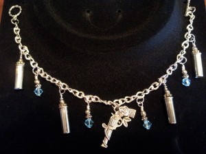 Bracelet with revolver charm, 22lr casing and blue crystals.